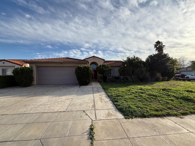 mediterranean / spanish house with stucco siding, an attached garage, a front yard, driveway, and a tiled roof