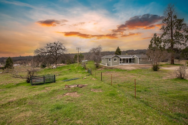 view of yard with a rural view and fence