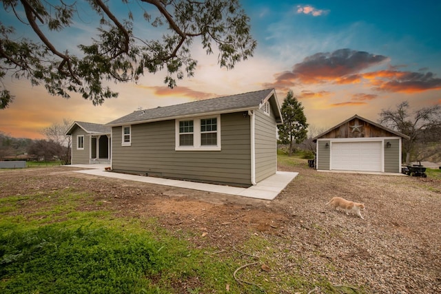 exterior space featuring a garage, an outdoor structure, and driveway