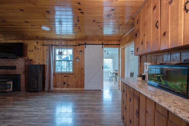 kitchen featuring dark wood-type flooring, wooden ceiling, a healthy amount of sunlight, and a barn door