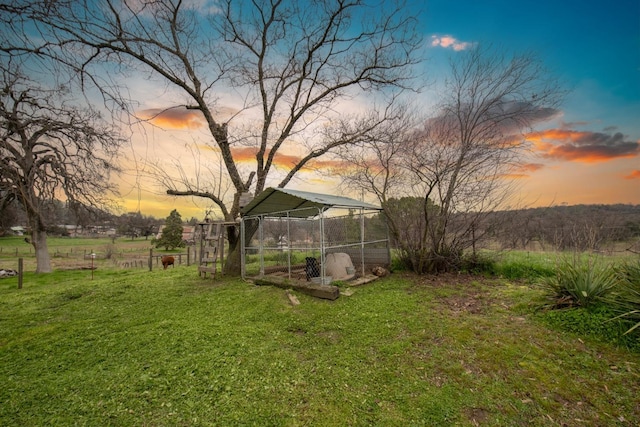 yard at dusk featuring an outbuilding