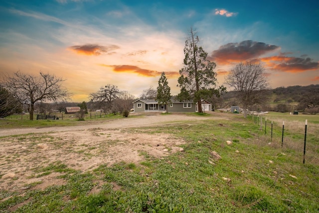 view of yard with a rural view and fence