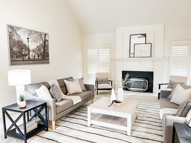 living room with a brick fireplace and vaulted ceiling