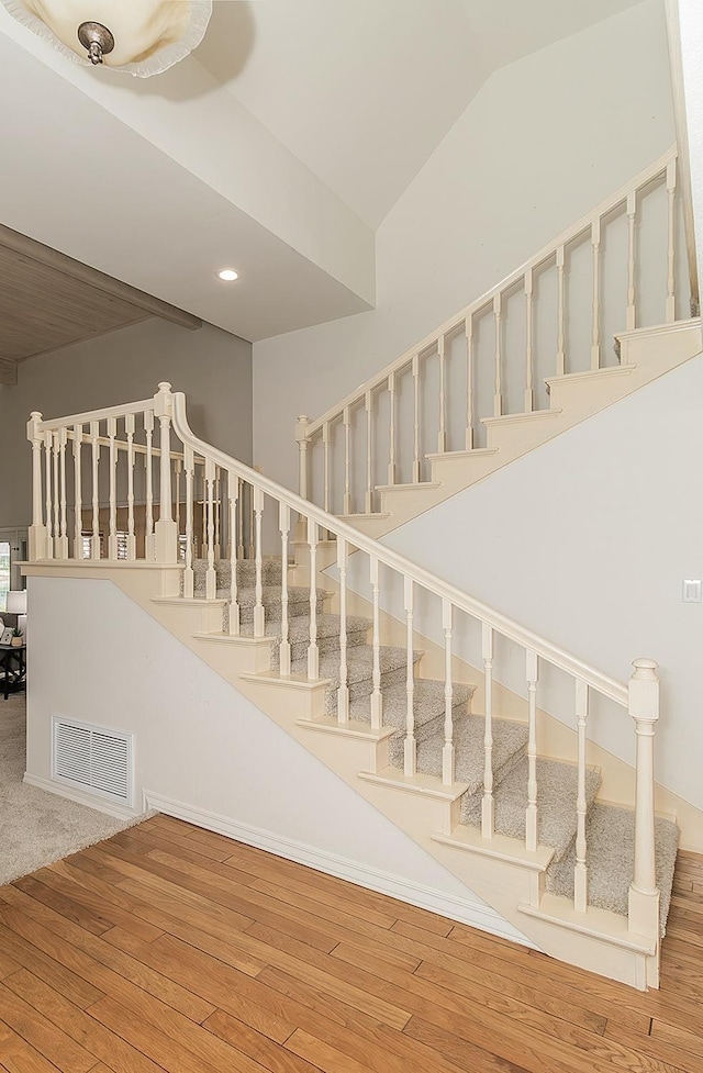 stairs featuring recessed lighting, visible vents, vaulted ceiling, and wood finished floors