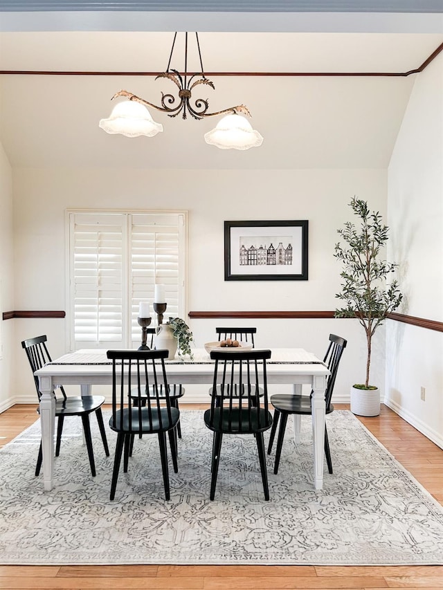 dining space with baseboards and wood finished floors