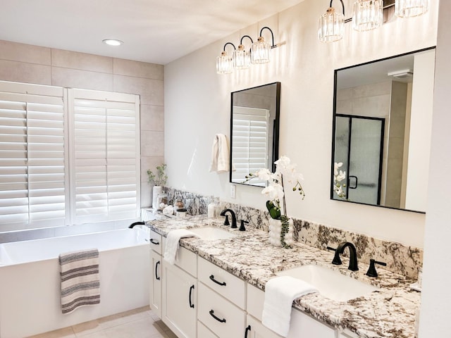 full bathroom featuring double vanity, a bathing tub, tile patterned flooring, a shower stall, and a sink