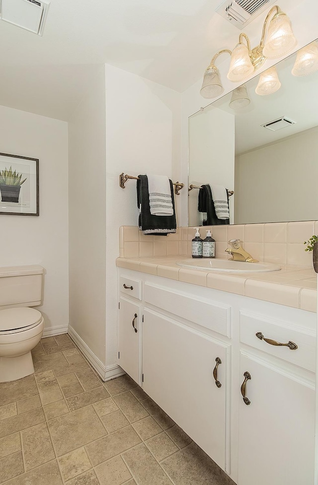 bathroom with visible vents, toilet, and vanity