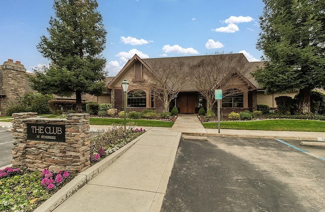 view of front of house featuring uncovered parking and a front lawn