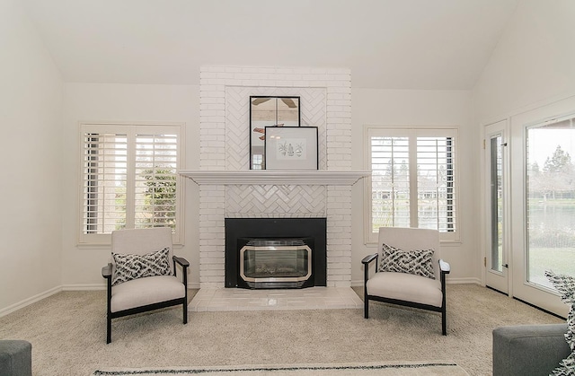 living area with vaulted ceiling, light carpet, plenty of natural light, and baseboards