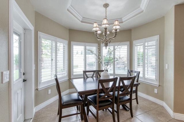 dining space with a chandelier, a tray ceiling, light tile patterned flooring, and baseboards