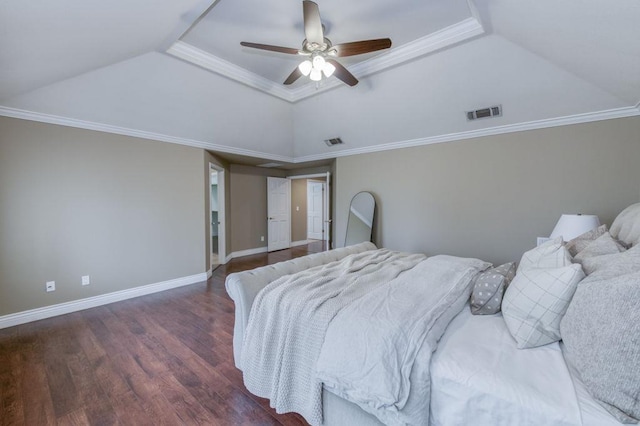 bedroom with lofted ceiling, visible vents, a tray ceiling, and dark wood finished floors