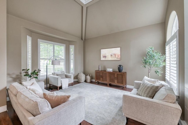 living room featuring vaulted ceiling with beams, dark wood finished floors, and baseboards