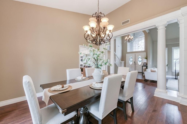 dining room with ornate columns, visible vents, dark wood-style flooring, and a notable chandelier