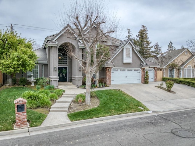 view of front facade with driveway, stucco siding, a tile roof, an attached garage, and brick siding