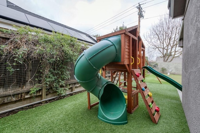 view of play area featuring a lawn and fence