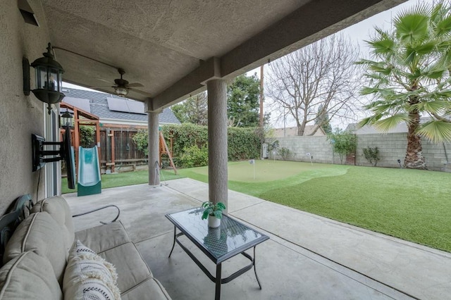 view of patio / terrace featuring a fenced backyard, a ceiling fan, an outdoor hangout area, and a playground