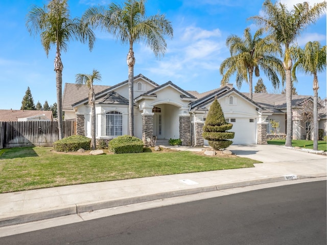 view of front facade with an attached garage, fence, concrete driveway, stucco siding, and a front lawn