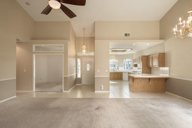 interior space with light tile patterned floors, light carpet, a high ceiling, a sink, and visible vents