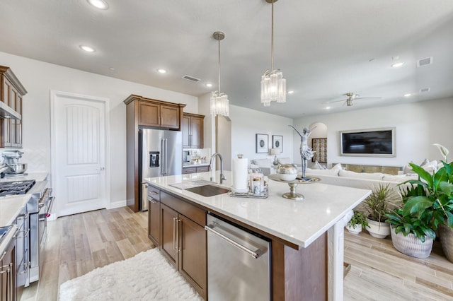 6375 E Millie Dr, Fresno, CA 93727 - kitchen featuring high quality appliances, a sink, light wood-style floors, recessed lighting, and pendant lighting