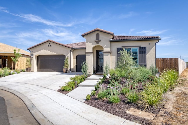 6375 E Millie Dr, Fresno, CA 93727 - mediterranean / spanish-style home featuring a garage, stucco siding, concrete driveway, and a tiled roof