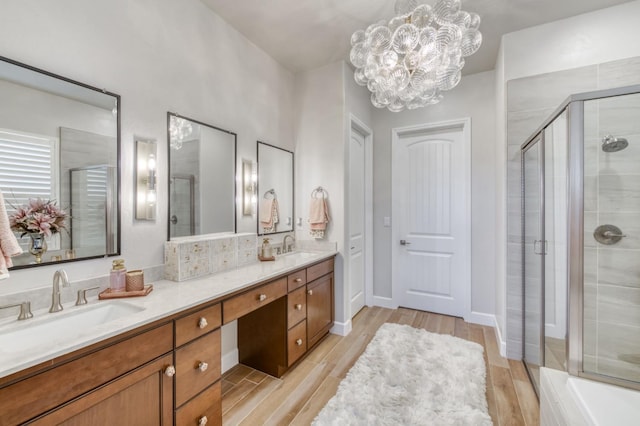 6375 E Millie Dr, Fresno, CA 93727 - full bathroom featuring double vanity, a shower stall, wood finished floors, a chandelier, and a tub to relax in