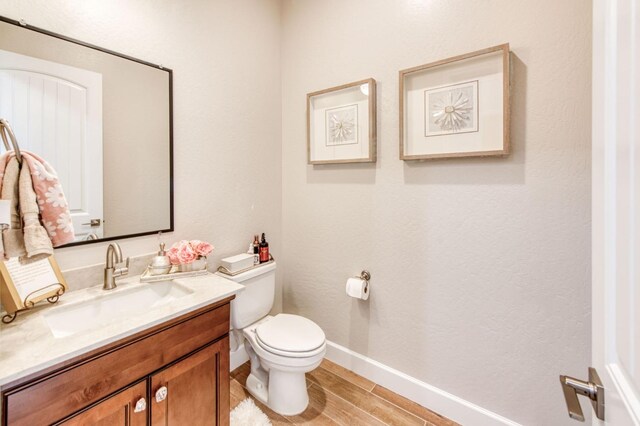 6375 E Millie Dr, Fresno, CA 93727 - bathroom featuring vanity, toilet, wood finished floors, and baseboards