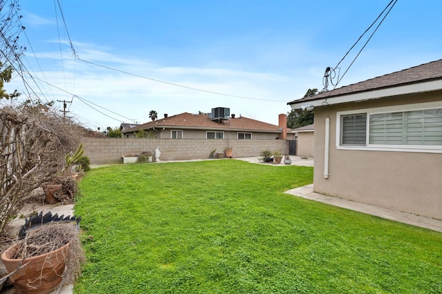 view of yard with central AC unit and a fenced backyard