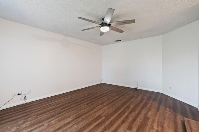 unfurnished room featuring visible vents, dark wood finished floors, a textured ceiling, and baseboards