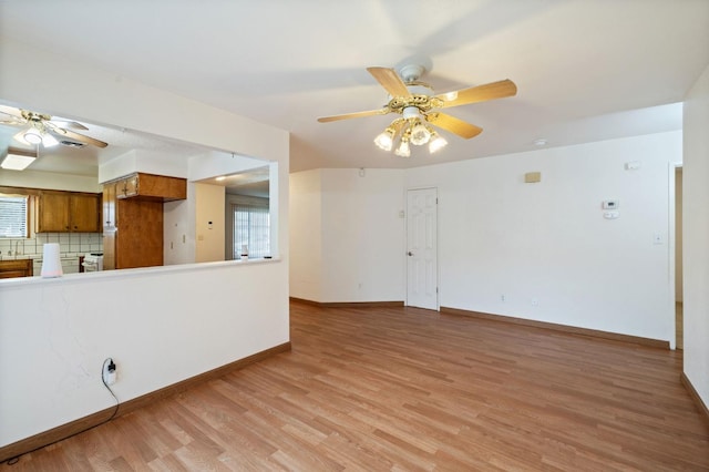 unfurnished living room with ceiling fan, light wood finished floors, and baseboards