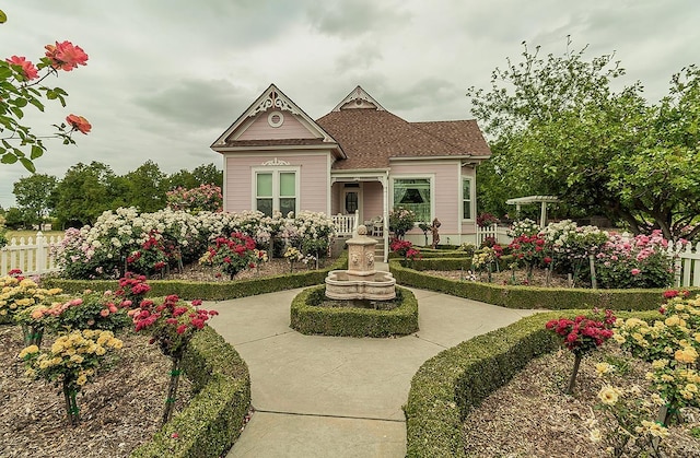 victorian home with fence and a shingled roof