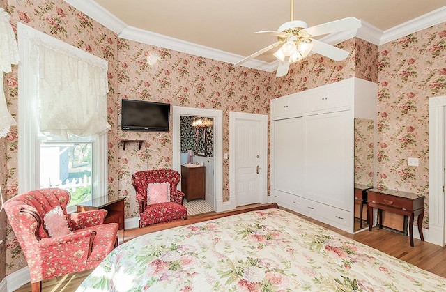 bedroom with wallpapered walls, ceiling fan, ornamental molding, wood finished floors, and a closet