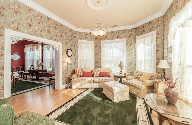 interior space featuring wood finished floors, visible vents, baseboards, wallpapered walls, and crown molding