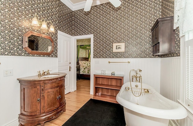 ensuite bathroom featuring a freestanding tub, wainscoting, connected bathroom, and wallpapered walls