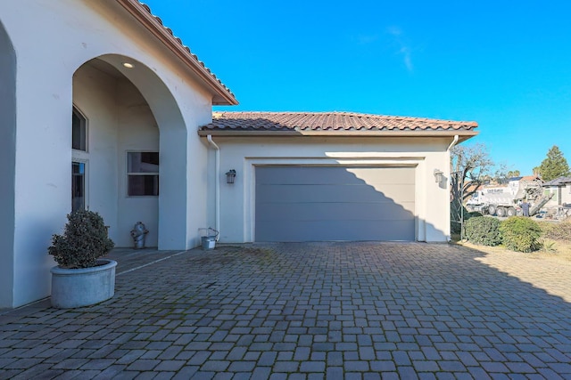 garage with decorative driveway