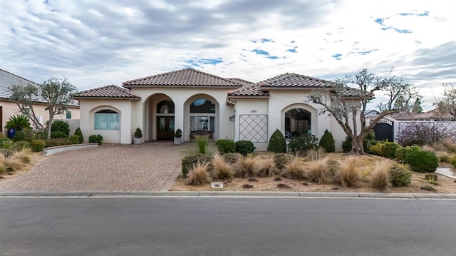 mediterranean / spanish-style house featuring a tiled roof and stucco siding