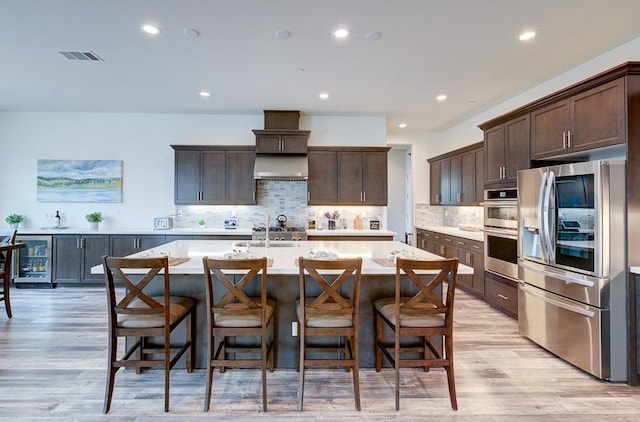 1048 Sawtooth Way S, Madera, CA 93636 - kitchen featuring appliances with stainless steel finishes, light countertops, dark brown cabinets, light wood-type flooring, and recessed lighting