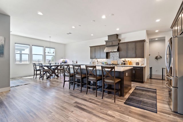 1048 Sawtooth Way S, Madera, CA 93636 - kitchen with freestanding refrigerator, a center island with sink, dark brown cabinetry, decorative backsplash, and recessed lighting