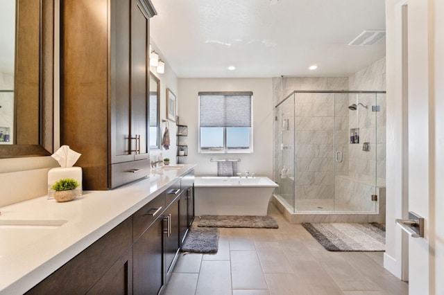 1048 Sawtooth Way S, Madera, CA 93636 - bathroom featuring a freestanding tub, double vanity, a stall shower, recessed lighting, and tile patterned flooring