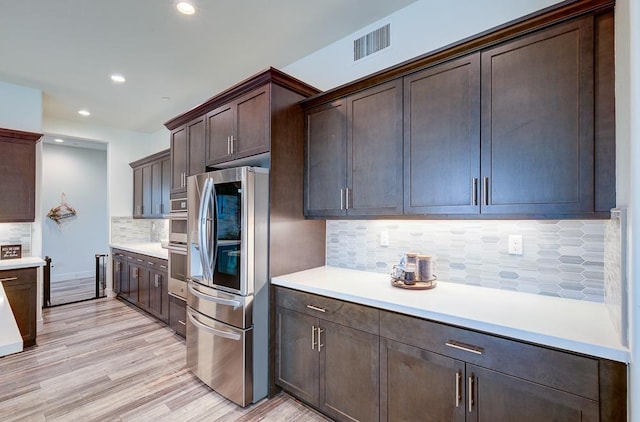 1048 Sawtooth Way S, Madera, CA 93636 - kitchen with stainless steel appliances, dark brown cabinets, decorative backsplash, light wood finished floors, and light countertops