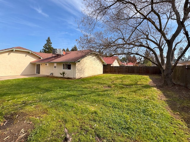 view of yard with a fenced backyard and central AC