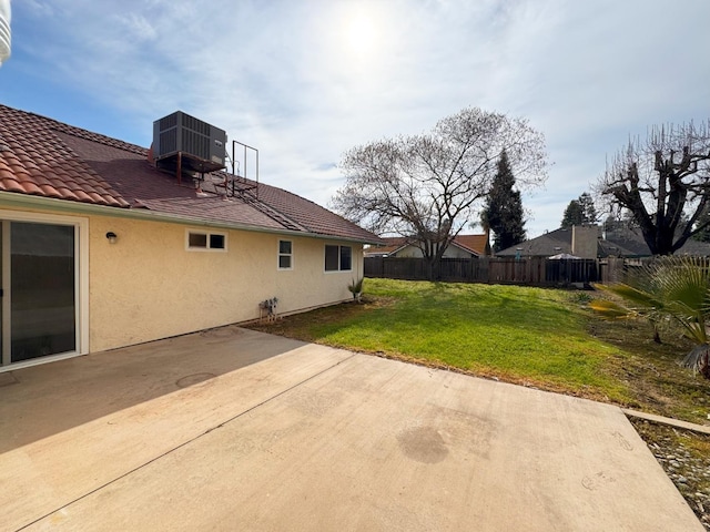 view of yard with a patio area, fence, and central AC