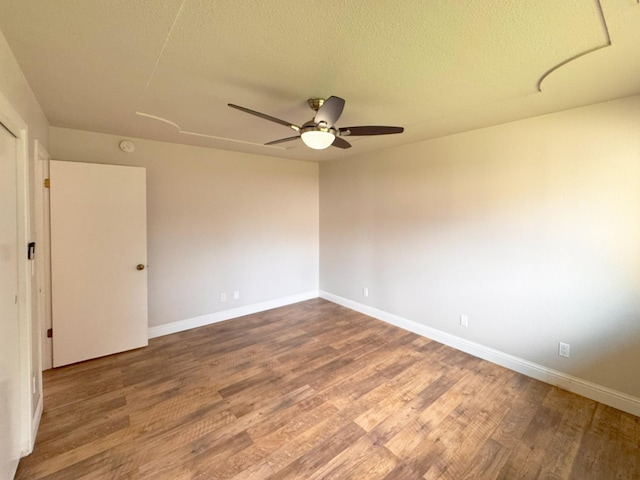 spare room with ceiling fan, baseboards, and wood finished floors