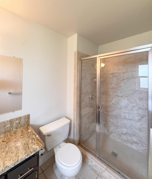 full bath featuring a textured ceiling, tile patterned flooring, toilet, vanity, and a stall shower