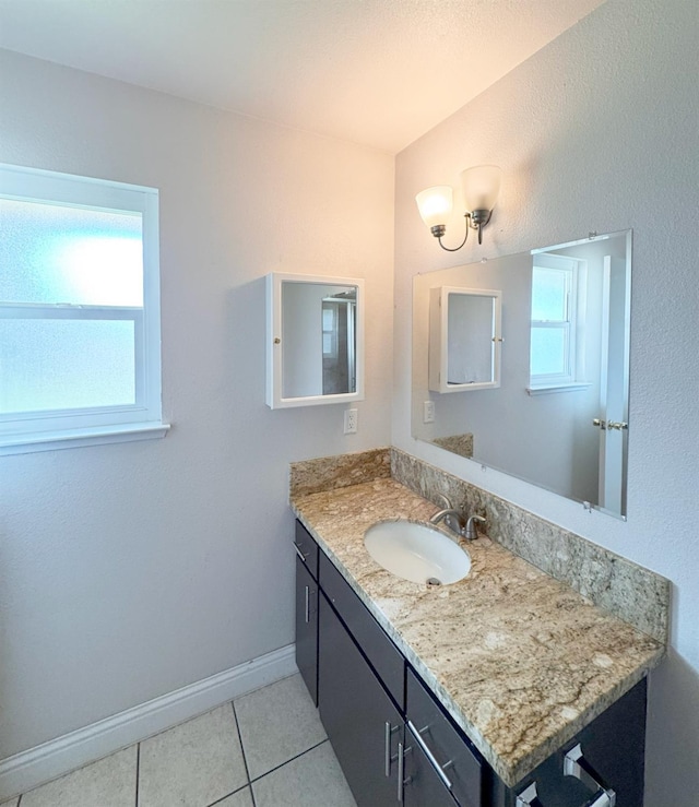 bathroom featuring tile patterned flooring, baseboards, and vanity