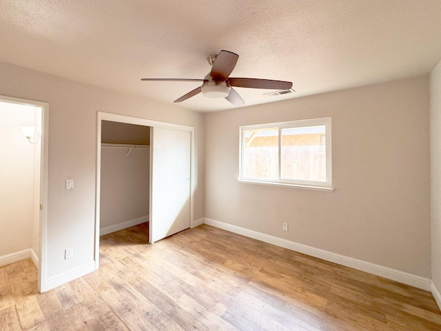 unfurnished bedroom featuring light wood-style flooring, visible vents, baseboards, and a closet