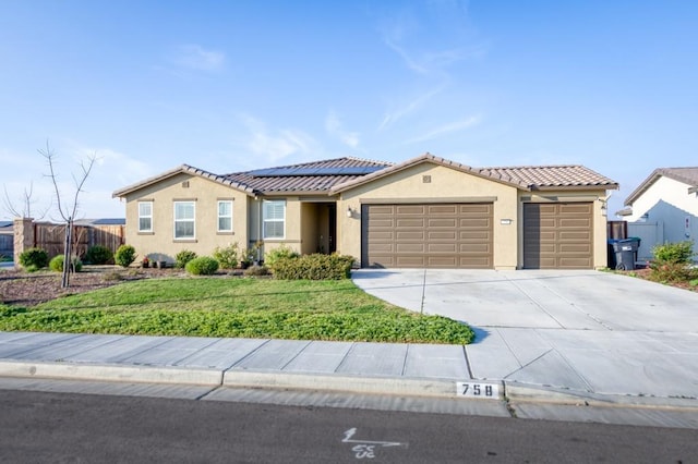 view of front facade with concrete driveway, stucco siding, an attached garage, and solar panels