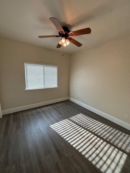 2136 Florence Ave, Sanger, CA 93657 - unfurnished room with dark wood-style flooring, baseboards, and a ceiling fan