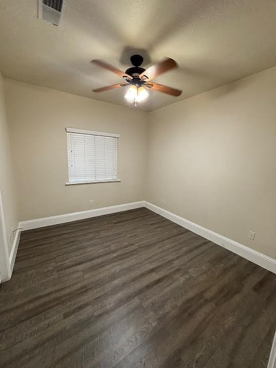 2136 Florence Ave, Sanger, CA 93657 - empty room featuring ceiling fan, baseboards, visible vents, and dark wood-style flooring