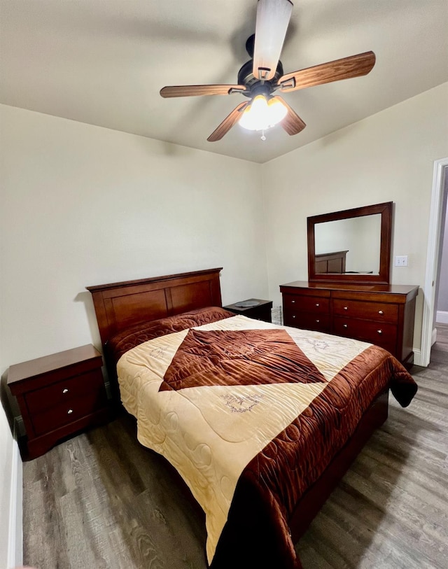 bedroom featuring baseboards, a ceiling fan, and dark wood-type flooring