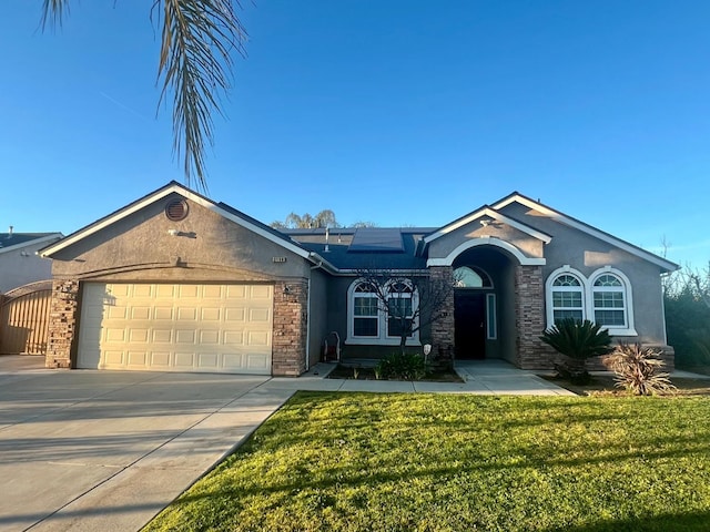 ranch-style home featuring concrete driveway, stucco siding, an attached garage, roof mounted solar panels, and a front yard